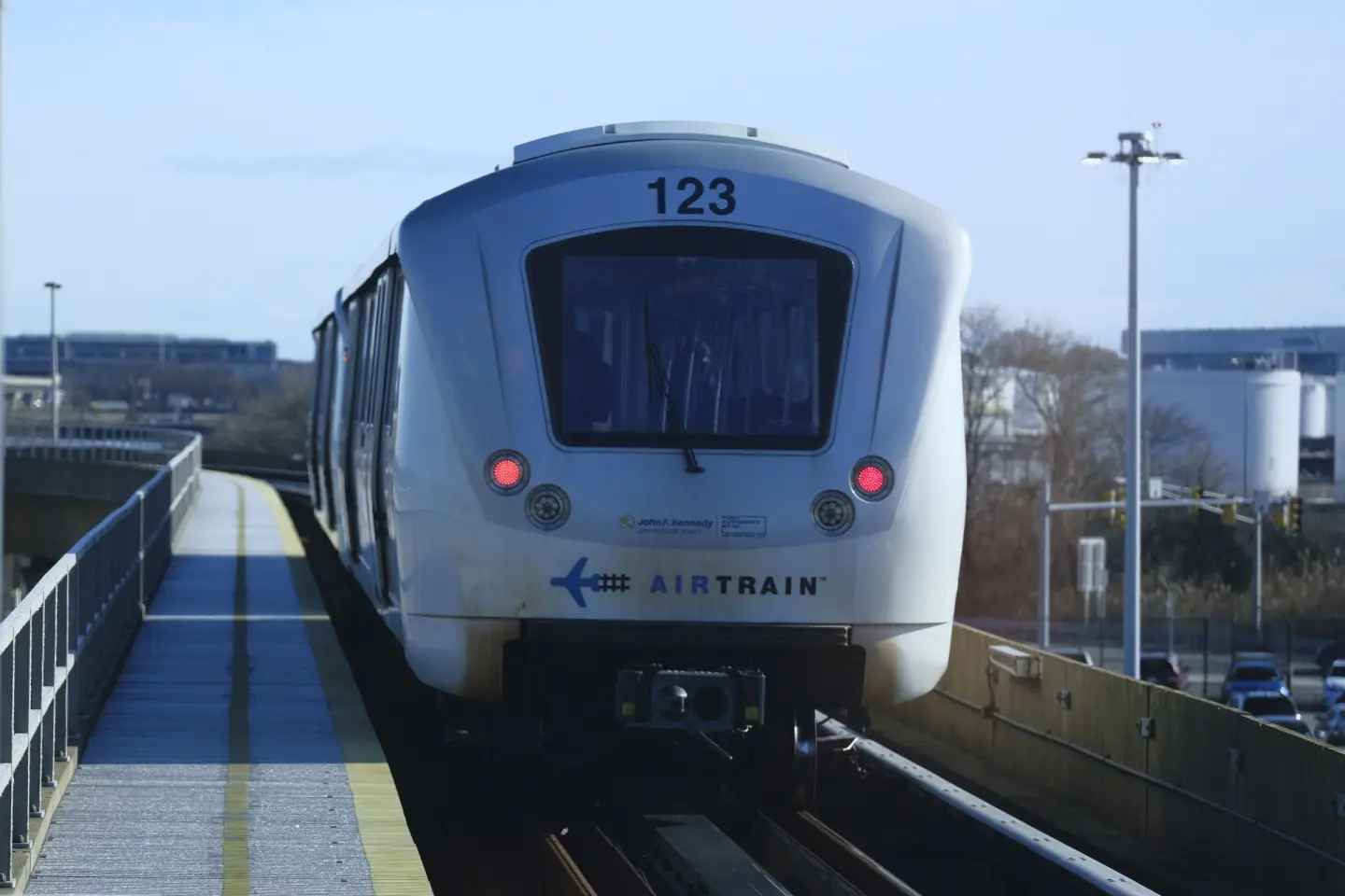 An AirTrain JFK car pulls into an elevated station platform at John F. Kennedy International Airport.